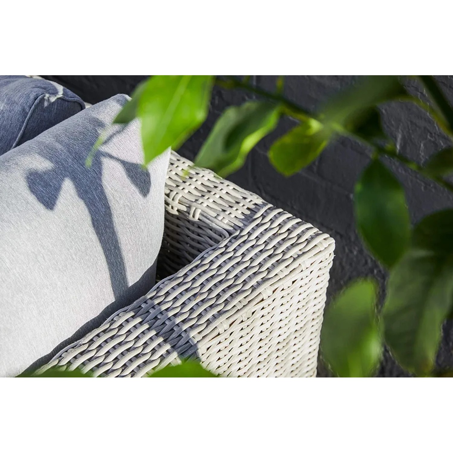 Detailaufnahme: Lounge-Sessel Olea aus Polyrattan in Sand mit hellgrauem Kissen.