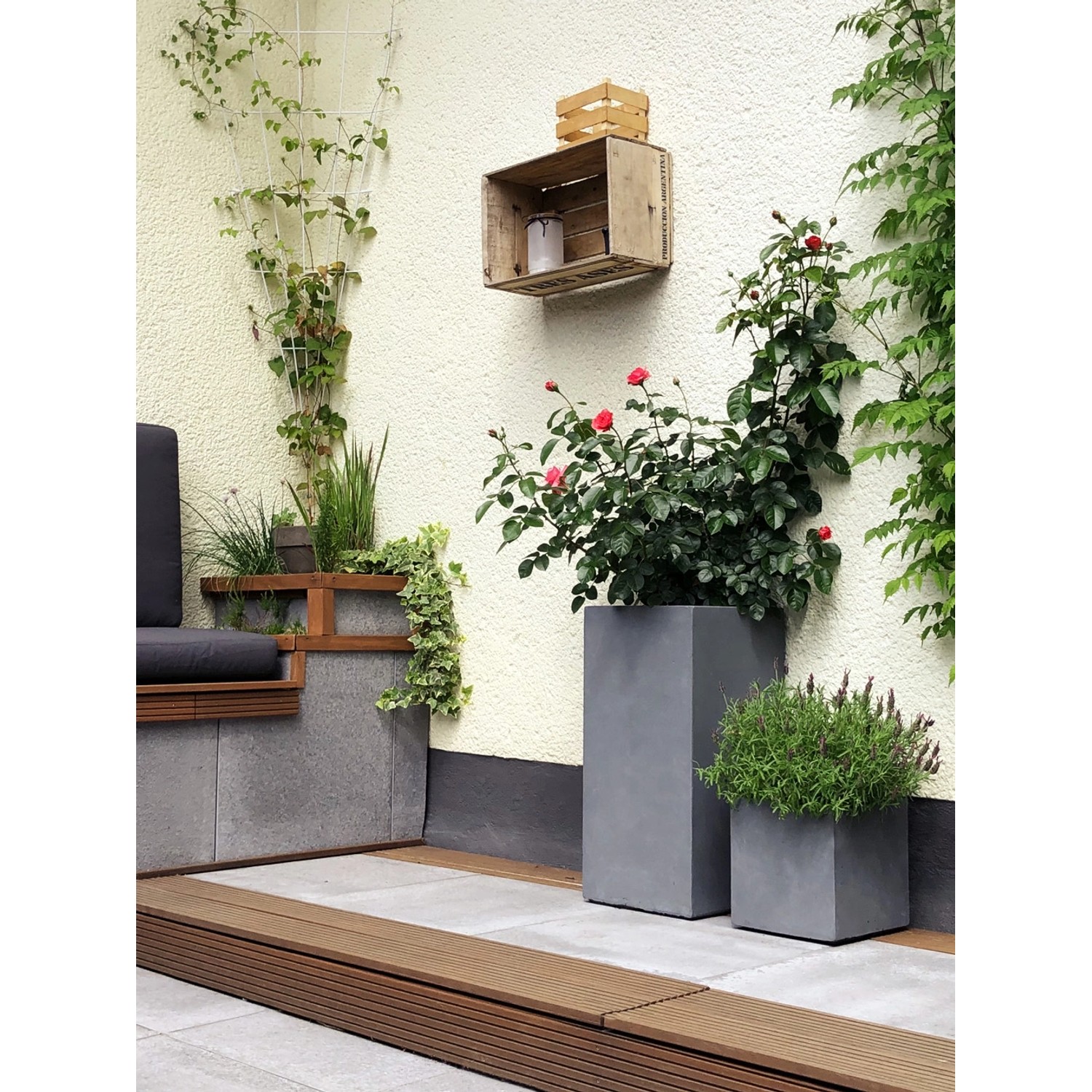 Graue Pflanzwerk® Tower Pflanzkübel (70 cm) im Garten mit Bepflanzung.