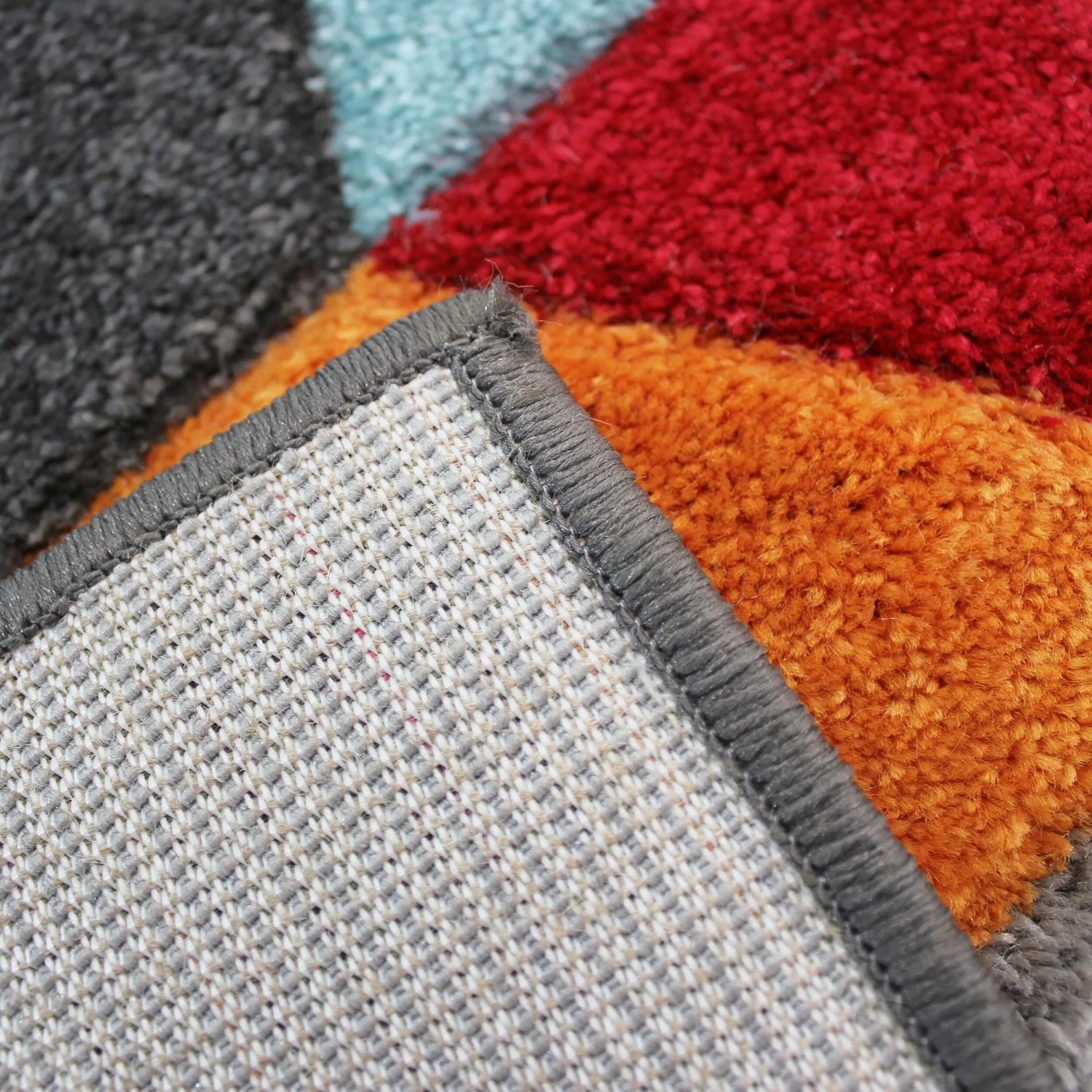 Nahaufnahme: Flair Rugs Kinderteppich Dynamic, mehrfarbig, flauschige Oberfläche, graue Kante, gewebte Unterseite.