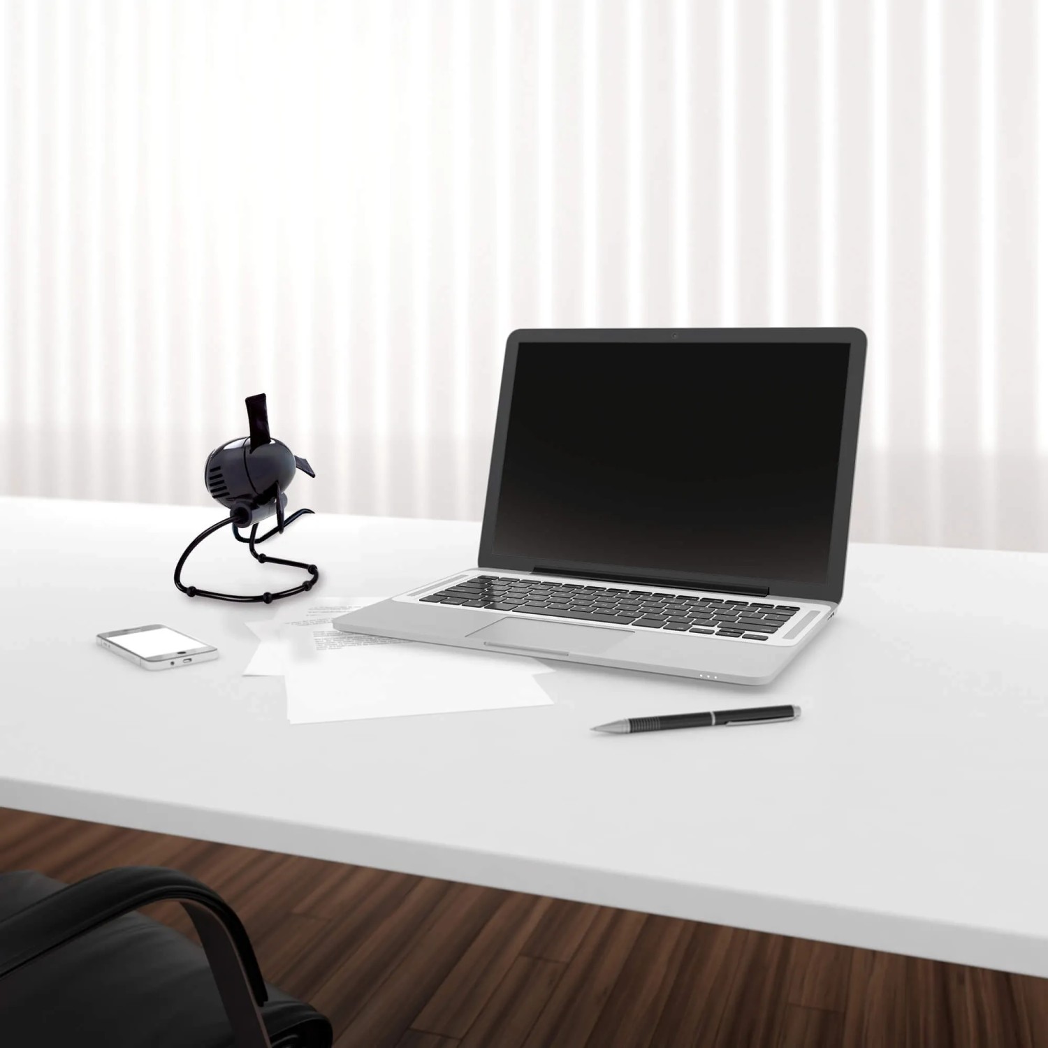 Schwarzer Vornado Zippi Tischventilator auf Schreibtisch mit Laptop und Smartphone.