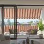 Spettmann Fallarmmarkise Line, weiß/gelb-orange-rot gestreift, 300x150cm, auf Balkon mit Möbeln.