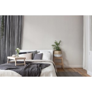 Schlafzimmer mit Vliestapete Uni Creme FSC® an der Wand, passend zum Interieur.