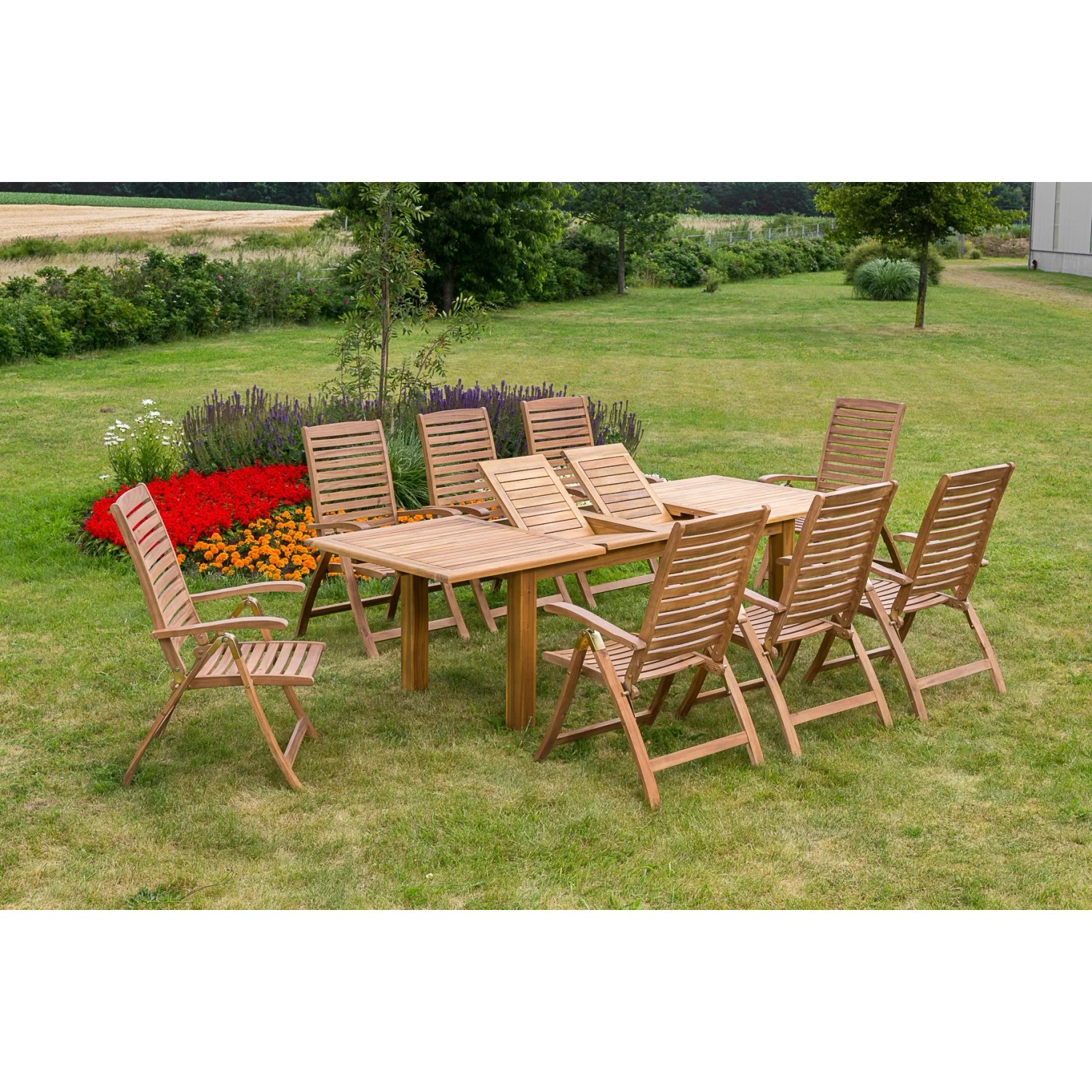 9-teiliges Gartenmöbel-Set Paraiba aus braunem Akazienholz mit Ausziehtisch auf einer grünen Wiese.