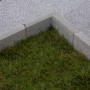 Graue, abgerundete EHL Rasenkantensteine aus Beton als Beeteinfassung.