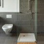 Wenko Baderost aus Bambus, 100x50 cm, vor Dusche im Badezimmer.