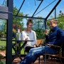 Juliana Gewächshaus Orangerie 15: Paar entspannt mit Wein im schwarz-anthrazitfarbenen Gewächshaus.