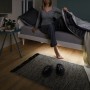 Frau sitzt auf Bett mit Paulmann MaxLED Night Comfort Set, das den Boden beleuchtet.