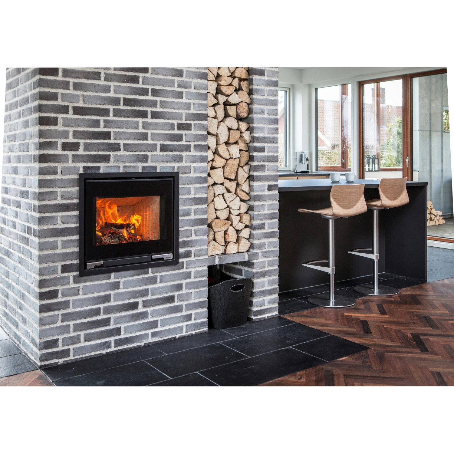 Aduro 5.1 Kaminofen, Stahl schwarz, 7 kW, mit Holzscheiten und Feuer im Brennraum.