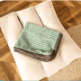 Grünes Petsation Ganzjahres-Hundebett (60 cm) mit Kissen und Decke auf Holzboden.