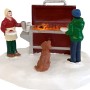 Weihnachtsdorf Figur: Grill-Camping Szene mit zwei Personen und Hund im Schnee. Detailreiche Weihnachtsdekoration.