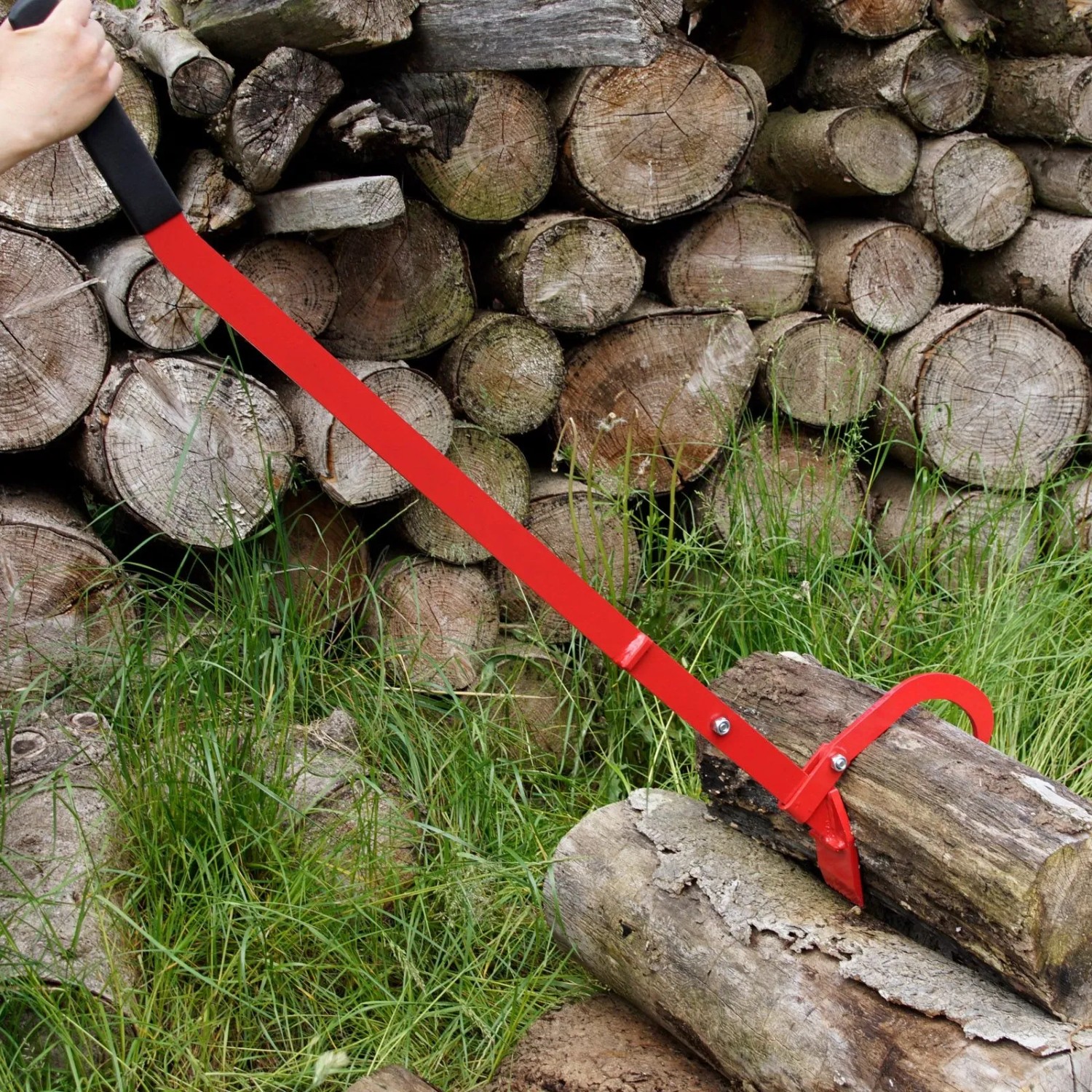 TRUTZHOLM Fällheber 130cm mit Wendehaken im Einsatz zum Heben eines Baumstamms vor Holzstapel.