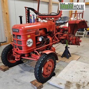 Roter Traktor auf TRUTZHOLM Unterstellbock (12t). Werkstatt, Wartung.