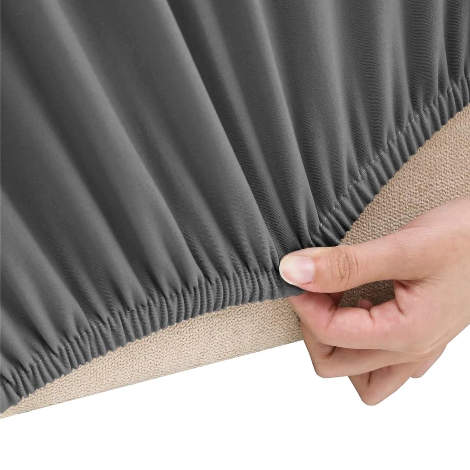 Nahaufnahme: Anthrazitfarbene Stretch Sofahusse (3-Sitzer) aus Polyester-Jersey wird über ein Sofa gezogen.