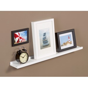 Weiße Bilderleiste Bix 80 cm mit Fotos und Deko an brauner Wand.