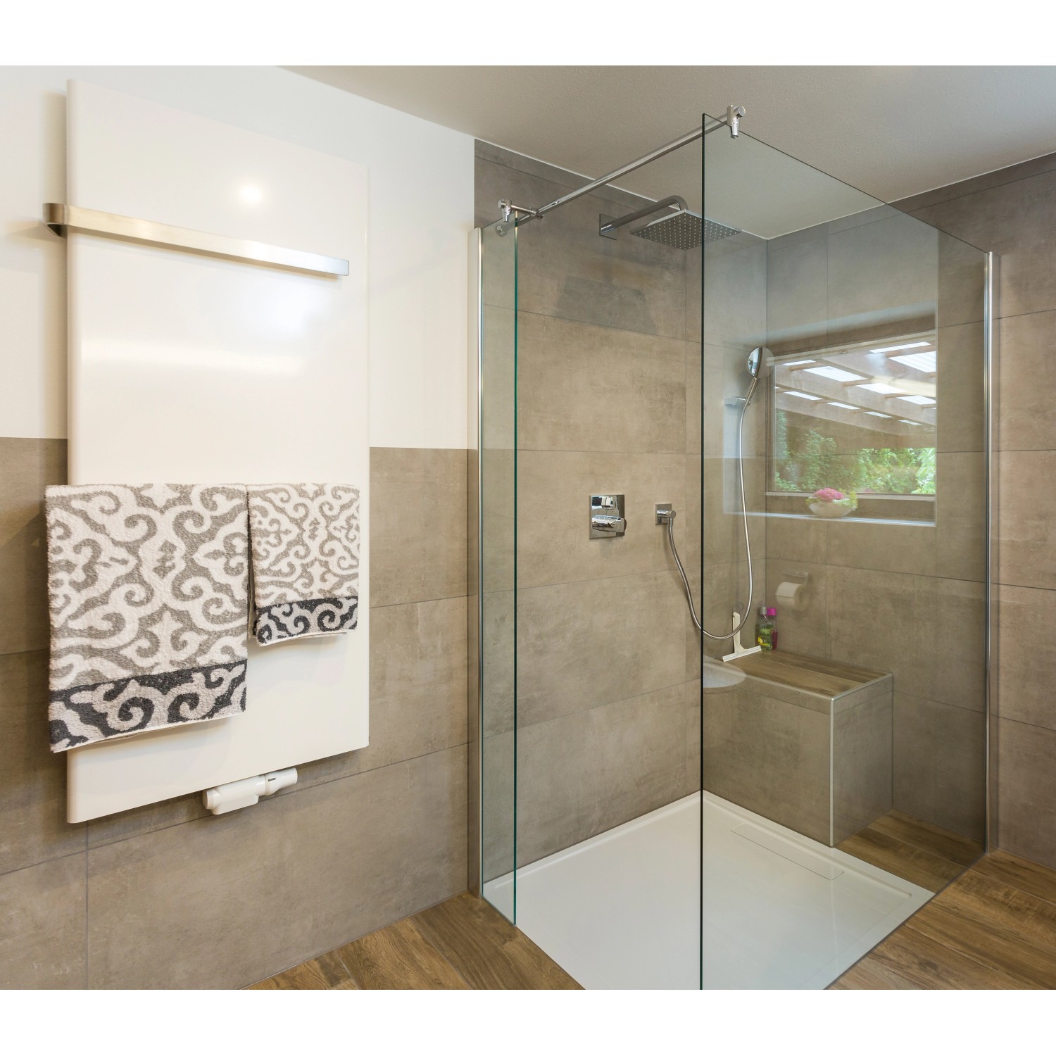 Modernes Badezimmer mit ebenerdiger Dusche, Handtuchheizkörper und grauen Fliesen.