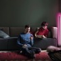 Schwarze Ledvance Smart+ WiFi Stehlampe Ecke, 142cm, mit indirekter, farbiger Beleuchtung im Wohnzimmer.