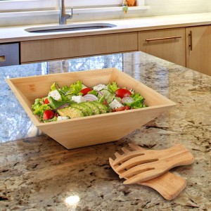 Salatschüssel aus Bambus mit Salatbesteck, gefüllt mit Salat. Naturfarbene Servierschüssel, 28 cm.