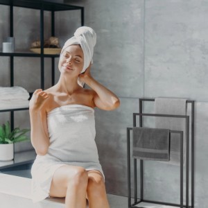 Freistehender, schwarzer Relaxdays Handtuchständer aus Stahl mit Handtüchern im Badezimmer.