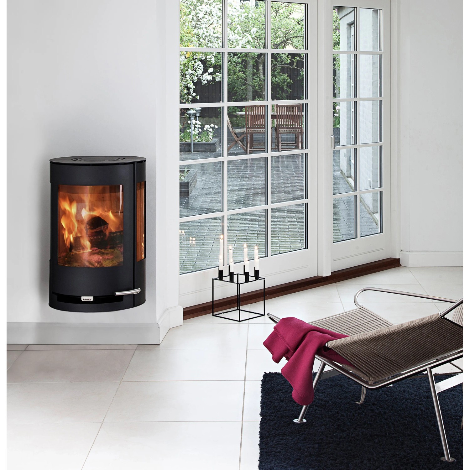 Aduro 9.4 Kaminofen, Stahl schwarz, 6 kW, mit Automatik im Wohnraum mit brennendem Feuer.