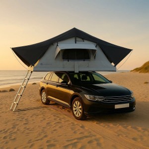 Juskys Autodachzelt Lago 140x240 cm, schwarz-grau, montiert auf einem Auto am Strand.