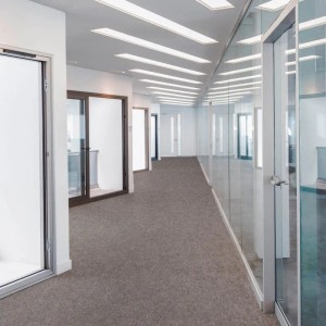 Kieselgrauer Eventteppich Turbo im Büroflur. Zuschneidbarer Teppichboden für Messen und Events.