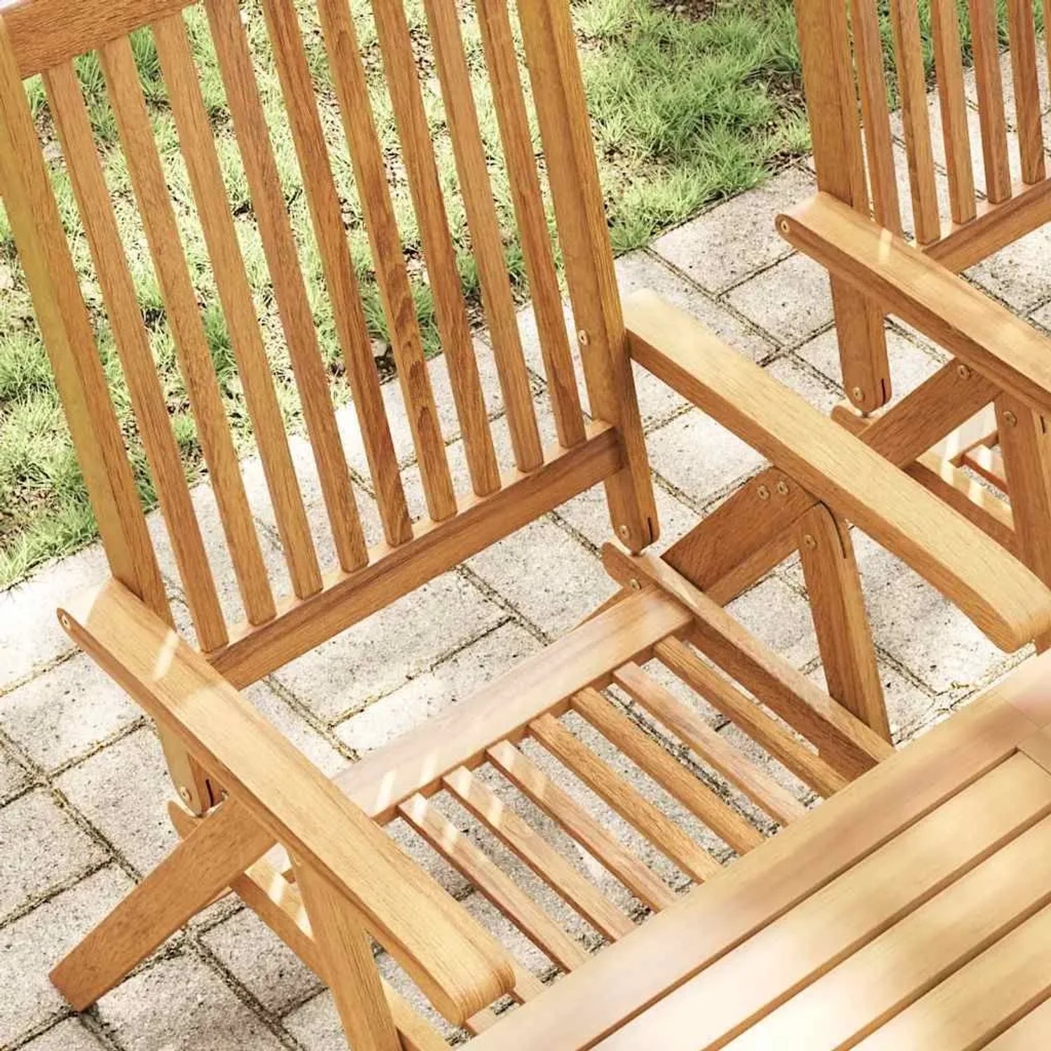 Zwei klappbare Gartenstühle aus geöltem Akazienholz auf einer Terrasse. Robustes Massivholz für den Außenbereich.