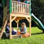 Axi Sarah Spielhaus mit Rutsche, braun-grün, mit Sandkasten und spielenden Kindern im Garten.