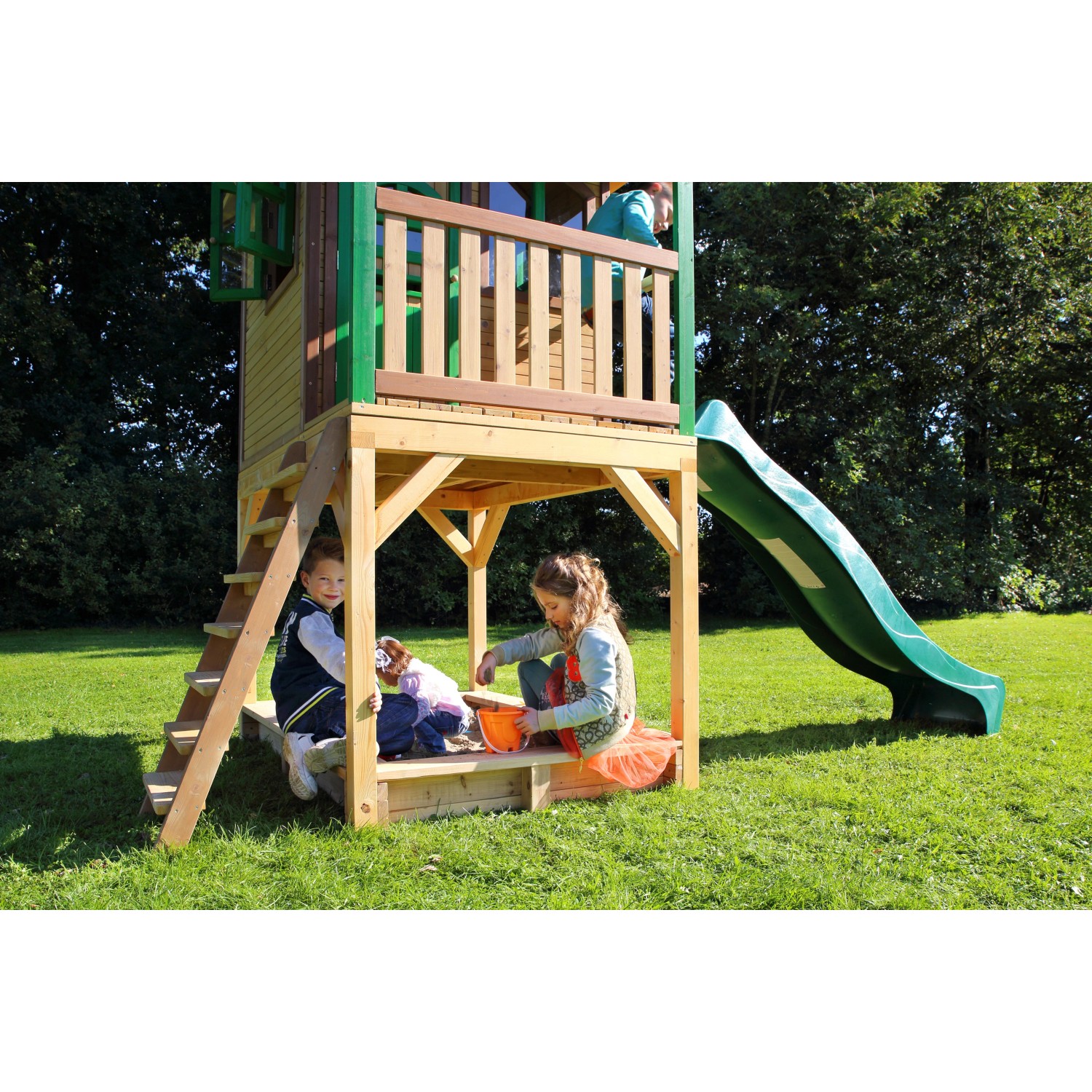 Axi Sarah Spielhaus mit Rutsche, braun-grün, mit Sandkasten und spielenden Kindern im Garten.