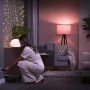 Frau steckt Philips Hue SmartPlug in die Steckdose. 4er Pack Hue Zwischenstecker für smarte Lampen und Geräte.