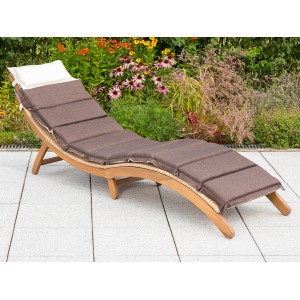 Gartenliege Capri aus Akazienholz mit brauner Auflage und weißem Kopfkissen vor blühendem Garten.