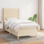 Cremefarbenes Boxspringbett (90x190 cm) mit Matratze und gestepptem Kopfteil.