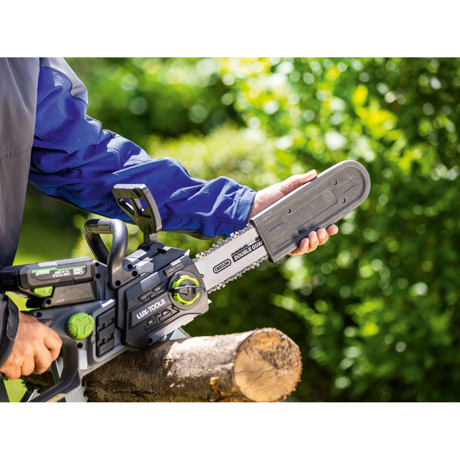 LUX-TOOLS 20V Akku-Kettensäge mit Kettenschutz sägt Holzstamm im Garten. Kabellose Motorsäge.