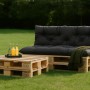 Anthrazit Palettenkissen Set: Sitz- und Rückenkissen auf Holzpaletten-Sofa mit passendem Tisch im Garten. Ideal für Loungemöbel.