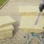 Wolfcraft Dämmstoffmesser schneidet Dämmstoffplatte auf Werkbank. Maurerwerkzeug mit 305 mm Klinge.