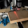 Scheppach HM216SPX Kapp-, Zug- und Gehrungssäge beim Sägen von Holz mit Laserführung.
