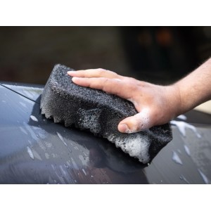 Hand reinigt Auto mit schwarzem Auto-Waschschwamm und Schaum. Autopflege.