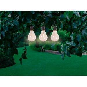 Drei Hänge-Solarleuchten in Glühbirnenform als Deko im Garten, warmweißes Licht.