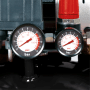 Detailaufnahme: Zwei Manometer des Einhell TE-AC 135/24 Silent Plus Kompressors zeigen Druck in PSI und Bar.