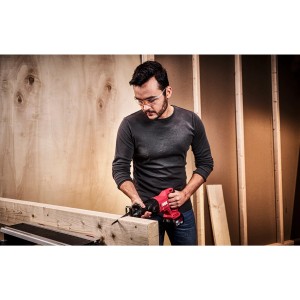 Mann sägt Holz mit roter Skil Akku-Säbelsäge 3471CA (ohne Akku/Ladegerät).