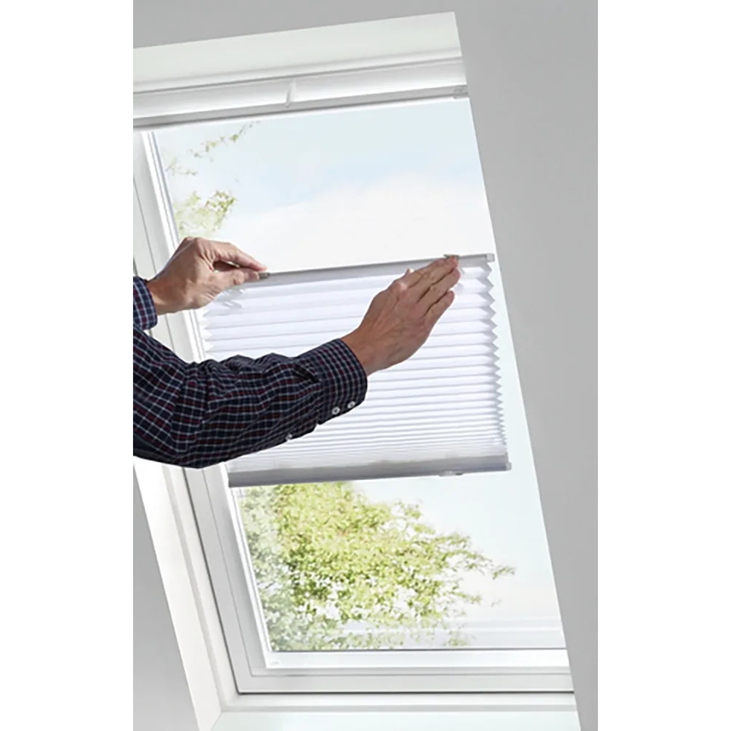 Weißes Gardinia Dachfenster-Plissee mit Saugnäpfen wird an einem Dachfenster angebracht.