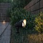 Schwarze Philips Cylr LED-Gartenstrahler Erdspießleuchte im Regen, warmweißes Licht.