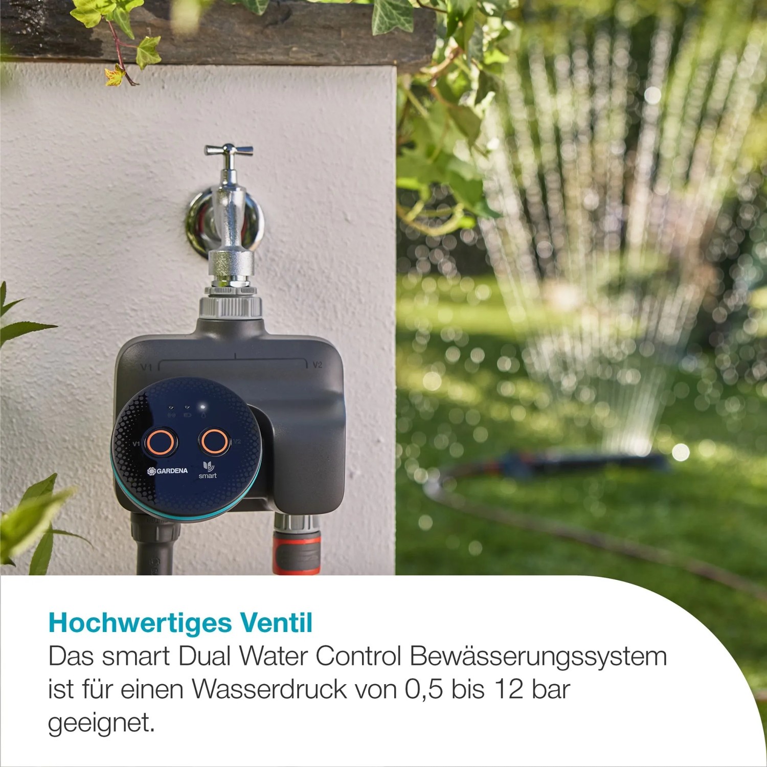 Gardena Smart Dual Water Control Bewässerungscomputer am Wasserhahn mit Rasensprenger im Hintergrund.