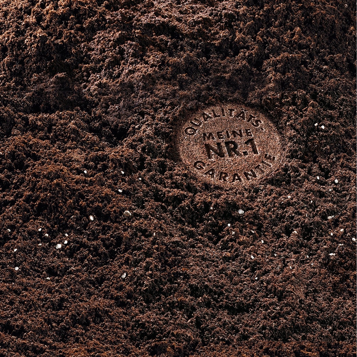 Nahaufnahme von Compo Sana Qualitäts-Blumenerde mit Qualitätsgarantie-Siegel.