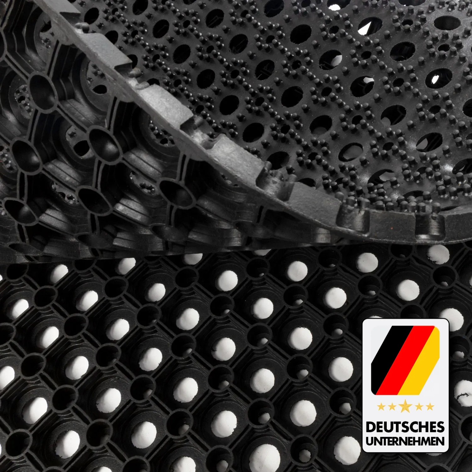 Schwarze KARAT Ringgummimatte Octo Door, recyclebar, mit Wabenstruktur und Löchern für Drainage.