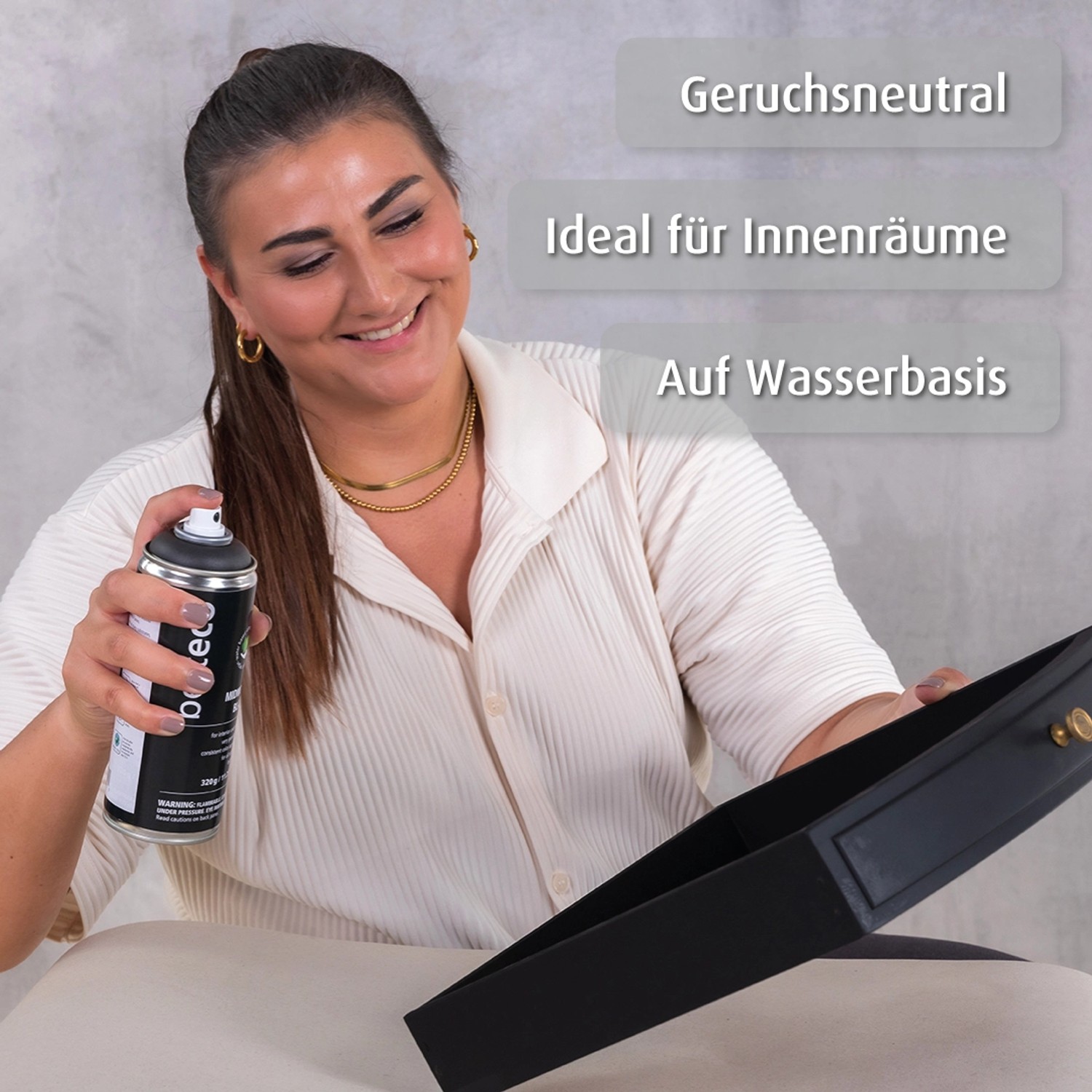 Frau sprüht belton Buntlack Perfect Deep Black seidenmatt auf Objekt. Design-Lackspray für Innen & Außen.