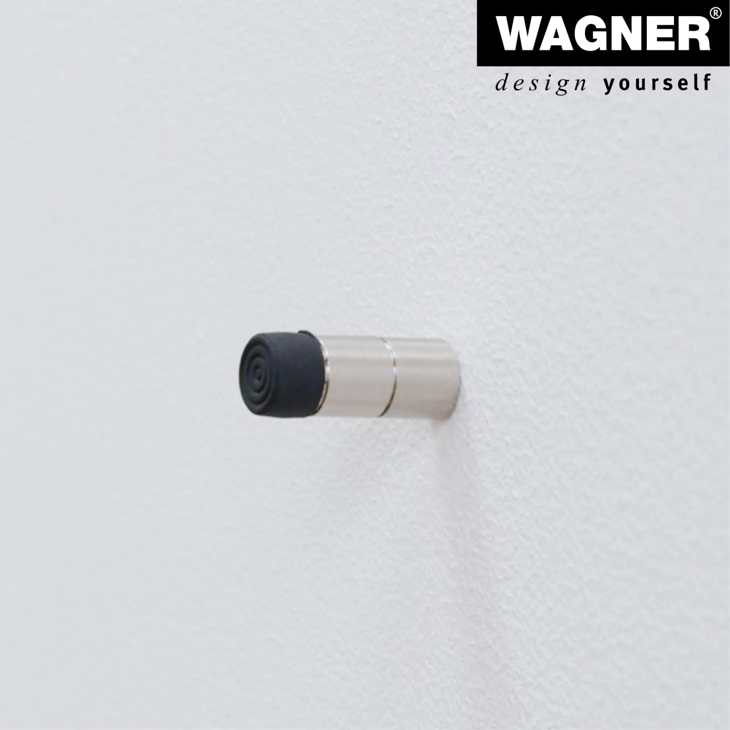 Wagner Wandtürstopper in Edelstahl-Optik mit schwarzem Elastomer an weißer Wand.