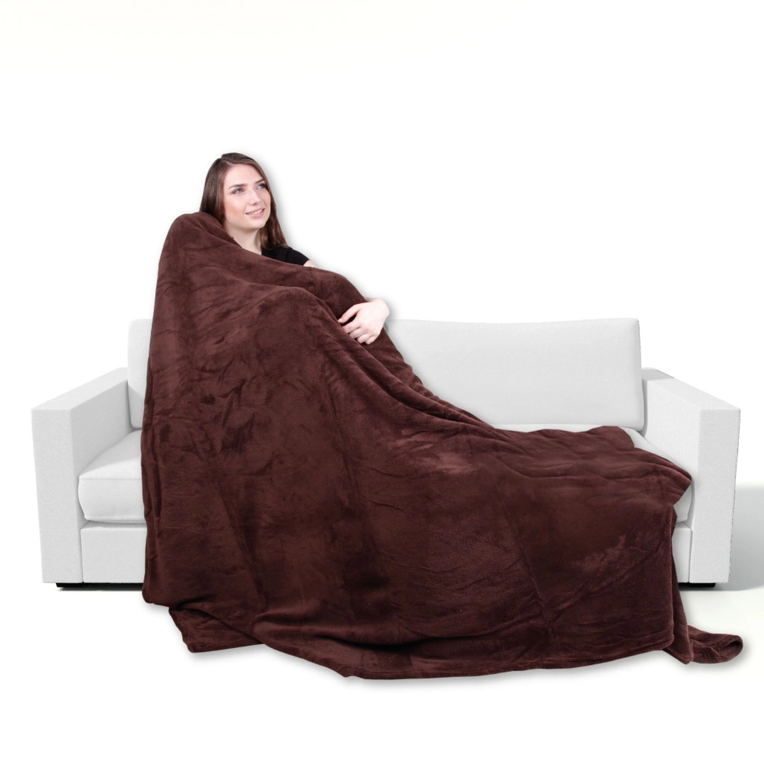 Frau kuschelt in braune Bestgoodies Mikrofaser Decke auf Sofa. Flauschige Wohndecke 220x240 cm.