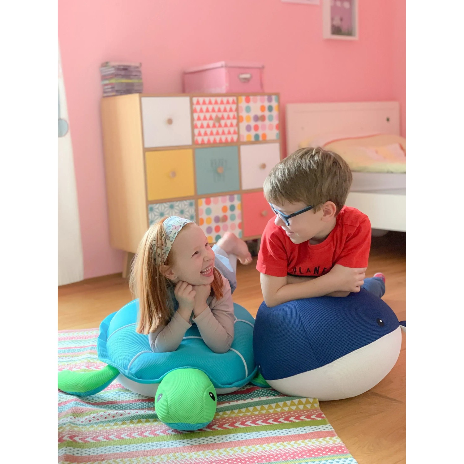 Kinder spielen mit Westmann Pool Buddy Wal (blau) und Schildkröte im Innenbereich.