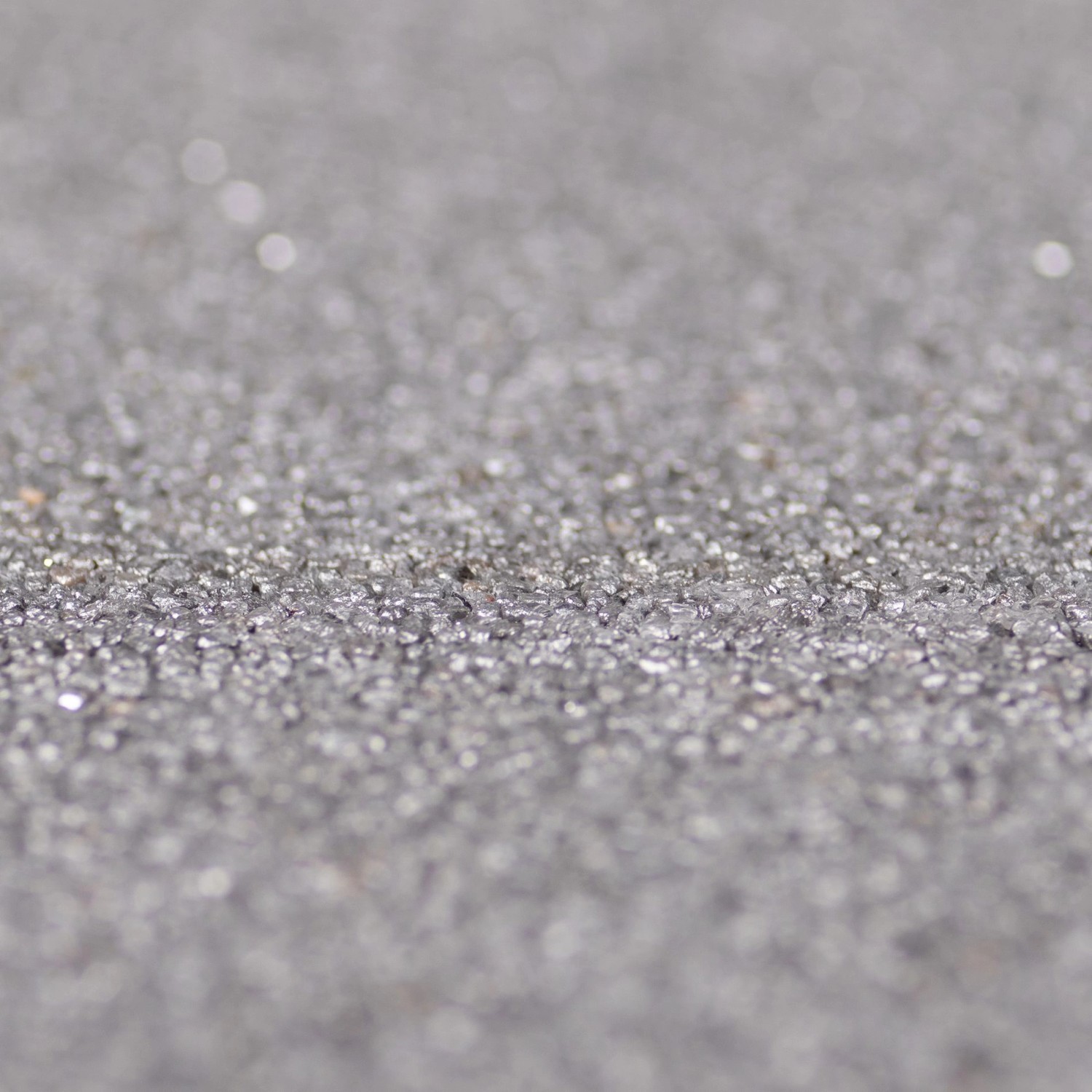 Nahaufnahme: Terralith Buntsteinputz Mosaikputz, 1mm Körnung, Farbe Grau.