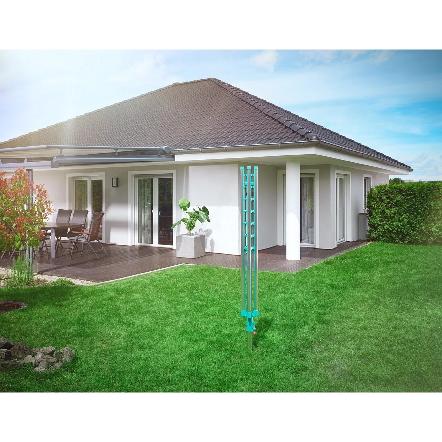 Zusammengeklappter Leifheit Wäscheschirm Linomatic 500 Easy im Garten vor einem Haus.